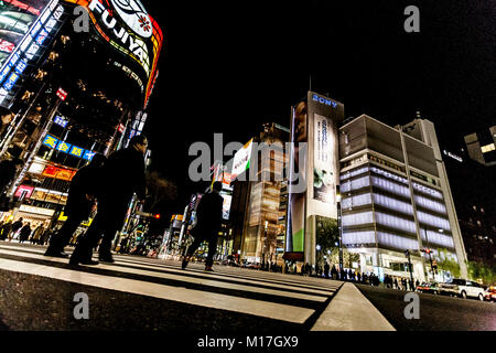 Tokio, Japan. Fußgänger die Straße überqueren im Herzen von Ginza in Tokio. Ginza Kreuzung bei Nacht. Verschwommene Bewegung. Stockfoto