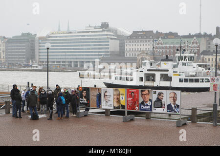 Helsinki, Finnland, 28. Januar, 2018. Die Menschen auf dem Marktplatz an die Plakate der Präsidentschaftskandidaten in den Tag der ersten Runde der Präsidentschaftswahlen. Die zweite Runde wird am 11. Februar stattfinden wird, falls erforderlich Stockfoto