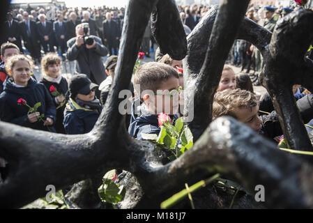 Thessaloniki, Griechenland. 28 Jan, 2018. Kinder Blumen auf den Holocaust Denkmal während einer Zeremonie zum Gedenken an die jüdischen Verfolgung während des Zweiten Weltkriegs. Vor dem Zweiten Weltkrieg fast 50.000 Juden in Thessaloniki. Nach dem deutschen Einmarsch in Griechenland zu Beginn des Zweiten Weltkrieges, fast 45.000 starben im Konzentrationslager Auschwitz. Credit: Giannis Papanikos/ZUMA Draht/Alamy leben Nachrichten Stockfoto