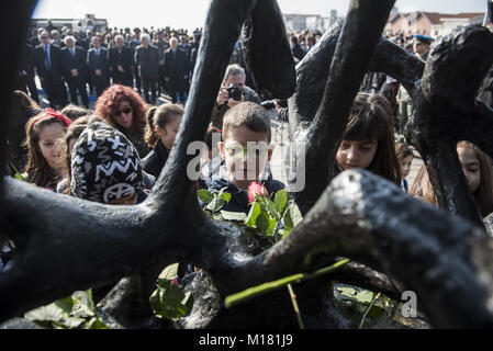 Thessaloniki, Griechenland. 28 Jan, 2018. Kinder Blumen auf den Holocaust Denkmal während einer Zeremonie zum Gedenken an die jüdischen Verfolgung während des Zweiten Weltkriegs. Vor dem Zweiten Weltkrieg fast 50.000 Juden in Thessaloniki. Nach dem deutschen Einmarsch in Griechenland zu Beginn des Zweiten Weltkrieges, fast 45.000 starben im Konzentrationslager Auschwitz. Credit: Giannis Papanikos/ZUMA Draht/Alamy leben Nachrichten Stockfoto