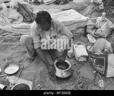 Jaisalmer, Indien - Mar 4, 2012. Ein Mann kochen Mahlzeit während der Kamel Safari In Jaisalmer, Indien. Camel Safaris in die Wüste sind sehr beliebt bei den Touris Stockfoto