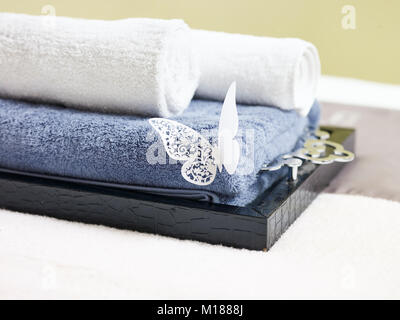 Gerollte Handtücher auf ein Fach auf Massage Bett im Beauty Spa und Health Club. Stockfoto