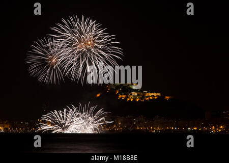 Feuerwerk in San Juan de Alicante mit Santa Barbara im Hintergrund das Schloss, Costa Blanca, Alicante, Spanien. Stockfoto