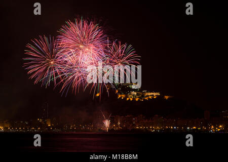 Feuerwerk in San Juan de Alicante mit Santa Barbara im Hintergrund das Schloss, Costa Blanca, Alicante, Spanien. Stockfoto