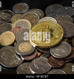Golden bitcoin über einem Haufen verschiedener Münzen. Stockfoto