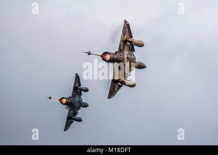 Französische Luftwaffe Couteau Delta display Team paar Mirage 2000 jet Jagdflugzeuge. Ziehen harte mit Nachbrenner erwärmen und Wolken von Kondensation Stockfoto