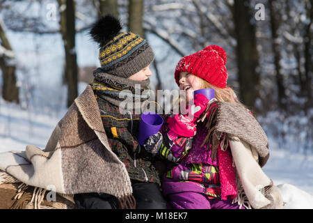 Mädchen und Jungen haben Gespräch und trinken heiße Getränke im Freien Stockfoto