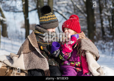 Mädchen und Jungen haben Gespräch und trinken heiße Getränke im Freien Stockfoto