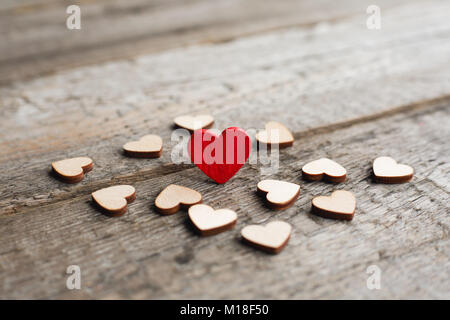 Wahre Liebe Konzept, Kleine rote Herzen mit anderen Herzen auf Holz- Hintergrund mit Kopie Raum umgeben Stockfoto