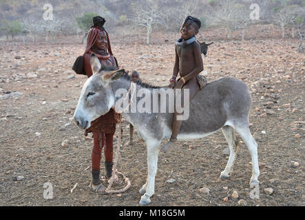 Verheiratet Himbafrau mit Mädchen auf einem Esel, Kaokoveld, Namibia Stockfoto
