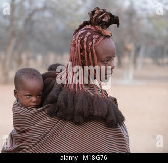 Junge, verheiratete Frau mit einem Baby im Tuch, Porträt, Kaokoveld, Namibia Stockfoto