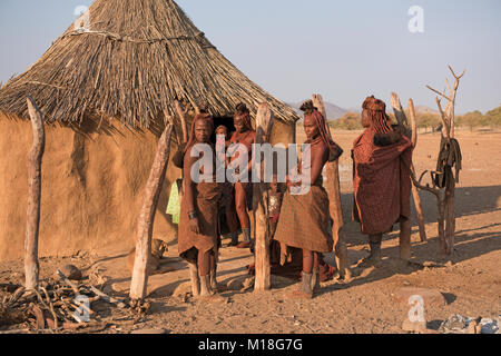 Himba Frauen mit kleinen Kindern vor ihrer Hütte, Kaokoveld, Namibia Stockfoto