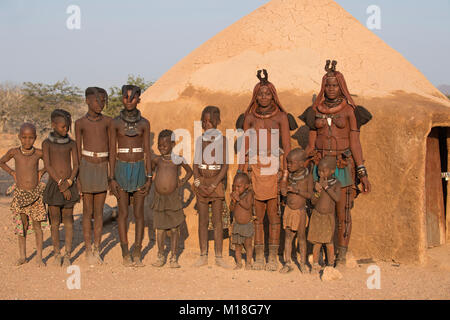 Himba Frauen und Kinder vor einer Lehmhütte, Kaokoveld, Kunene, Namibia Stockfoto