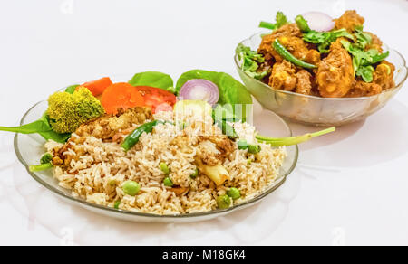 Indisches essen von Gemüse gebratener Reis und würzige Chicken kosha auf weißem Hintergrund. Eine beliebte Bengali essen. Stockfoto