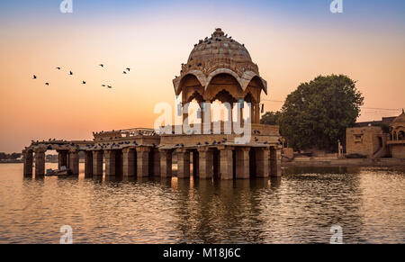 Sonnenuntergang am Gadisar See (Gadi Sagar) Jaisalmer, Rajasthan mit alter Architektur und Vögel. Stockfoto