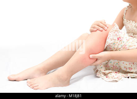 Schmerzen im Bein oder Wade Muskel in ein Mädchen auf dem Bett auf weißem Hintergrund, gesunde Konzept Stockfoto