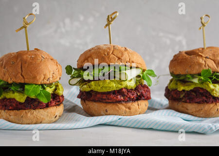 Vegan Zuckerrüben Burger mit Gemüse, Guacamole und Roggen Brötchen mit grünen Saft. Gesunde vegane Ernährung Konzept. Stockfoto