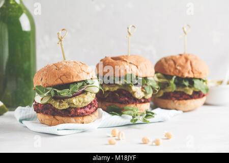 Vegan Zuckerrüben Burger mit Gemüse, Guacamole und Roggen Brötchen mit grünen Saft. Gesunde vegane Ernährung Konzept. Stockfoto