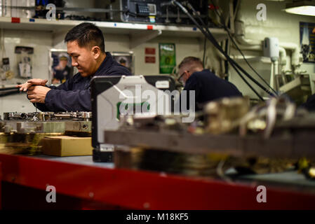 ARABIAN GULF (Jan. 25, 2018) der Luftverkehr strukturellen Mechaniker Flieger Johnny Yang Reparaturen eine ordnance Plattform an Bord der Flugzeugträger USS Theodore Roosevelt (CVN 71). Theodore Roosevelt und ihre Carrier strike Group werden in den USA 5 Flotte Bereich für Maßnahmen zur Erhöhung der Sicherheit im Seeverkehr im Einsatz Verbündeten und Partnern zu beruhigen und der Freiheit der Schiffahrt und des freien Handels in der Region erhalten. (U.S. Marine Stockfoto