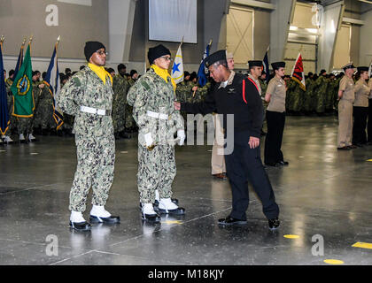 GREAT LAKES, Illinois (Dez. 14, 2017) der Luftfahrt Bootsmann Mate Handhabung 1. Klasse Kevin Marcellin demonstriert die richtige Flagge Handhabung zu den Rekruten während der Boot Camp Staffelung der Praxis Dezember 14, 2017, am Mittelweg zeremoniellen Drill Hall, Recruit Training Command. Der Drill Hall Personal ist verantwortlich für die Leitung der wöchentlichen Pass-in-Review Zeremonie, die Vor 2,000-5.000 Gäste nimmt nur Boot Camp der Marine. Zwischen 30,000-40,000 Rekruten Absolvent jährlich nur von Boot Camp der Marine. (U.S. Marine Stockfoto