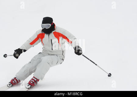 Alpine Skifahrer Skifahren bergab über weißen Schnee Hintergrund Stockfoto