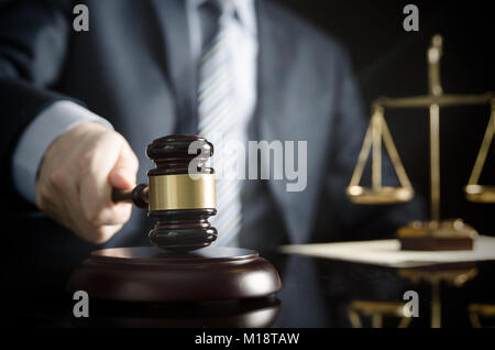 Rechtsanwalt oder Patentanwalt arbeitet in seinem Büro. Holz- Hammer in der Hand Stockfoto