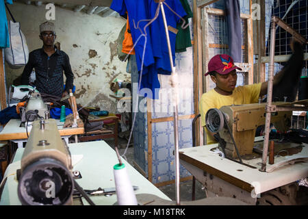 STONE Town, Sansibar - Dez 31, 2017: Maßgeschneiderte Männer nähen Bekleidung mit industriellen Maschinen in Werkstatt, Stone Town, Sansibar Stockfoto