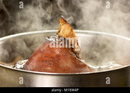 Schweinebraten Kochen in den Topf geben. Stockfoto