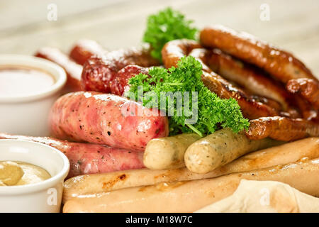 Schale mit sechs Arten von Würstchen auf Holzplatte, Nahaufnahme. Stockfoto