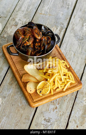 Ansicht von oben Topf mit Muscheln und Beilage. Stockfoto