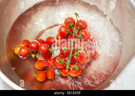 Kirsche Tomaten in eine Schüssel mit Wasser, Ansicht von oben. Stockfoto