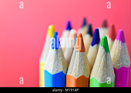 Mehrfarbige pensils auf rotem Hintergrund - Zurück zum Konzept der Schule - Nahaufnahme Stockfoto