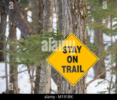 Gelbe Zeichen auf einem Snowmobile trails Warnung auf der Spur gehen durch einen Business Bereich in Spekulant zu bleiben, NY, USA Stockfoto