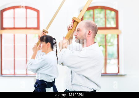 Mann und Frau in Aikido Schwertkampf Stockfoto