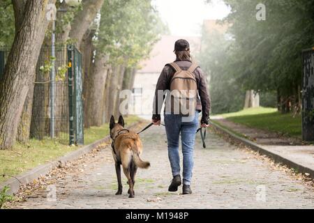 Frau und ihr Hund auf der Suche nach Häuser. die Entdeckung von verlassenen Gebäuden. post-Apokalypse. Stockfoto