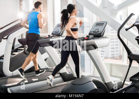 Menschen, die auf Laufbändern Stockfoto
