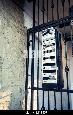 Zeitungen gefüllt in eine Wohnung letterbox auf einer metallischen Gate Stockfoto
