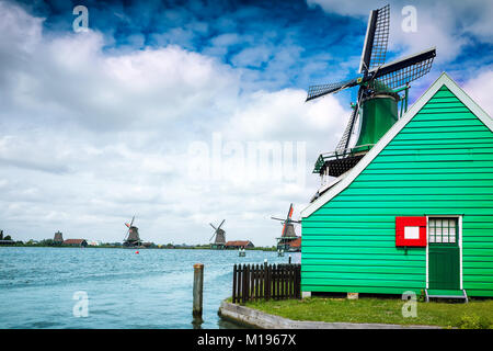 Holländische Windmühlen und Häuser auf dem zaans River von Zaanse Schans National Park und Museum in Nordholland Stockfoto