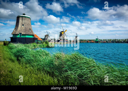 Holländische Windmühlen und Häuser auf dem zaans River von Zaanse Schans National Park und Museum in Nordholland Stockfoto