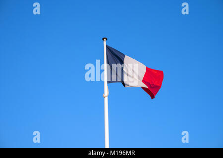 Französische Nationale offizielle Flagge auf und blauer Himmel. Symbol für Frankreich. Patriotische französische Banner, Design. Flagge Frankreich am Fahnenmast winken im Wind Stockfoto