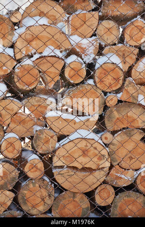 Stapel von Holz Holz bedeckt Verlegung mit Schnee Hintergrund Stockfoto