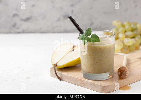 Smoothies von Birnen und Trauben in einem Glas auf einem weißen Hintergrund konkrete Stockfoto