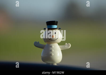 Ein lächelndes Kunststoff Schneemann steht vor einem unscharfen Hintergrund Stockfoto