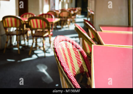 Typische Tabellen und Rattan Stühle auf der Terrasse in einem Pariser Café im Freien in der Sonne. Stockfoto