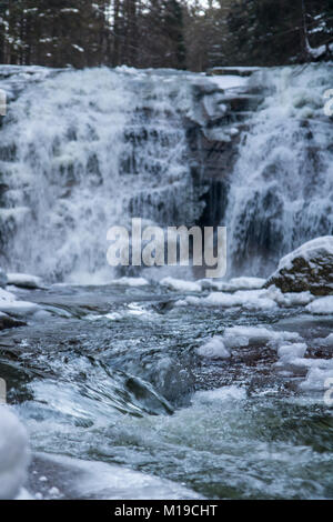 Wasserfall im verschneiten Wald. Winter Mumlava Wasserfall in Harrachov, Riesengebirge, Tschechische Republik Stockfoto