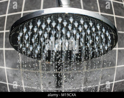 Fließt das Wasser aus der Dusche, close-up. Der Strom der fließt das Wasser aus dem Duschkopf. Stockfoto