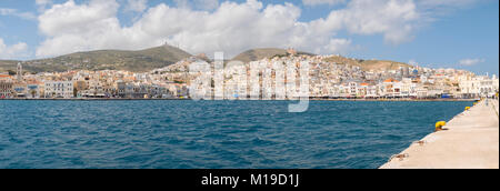 SYROS, Griechenland - 10 April, 2016: Blick von Syros Hafen mit schönen Gebäuden und Häusern an einem sonnigen Tag mit Wolken Stockfoto