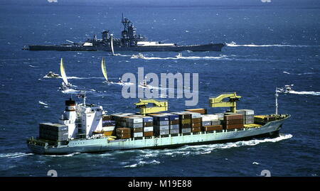 AJAXNETPHOTO. 16. Oktober, 1986. FREMANTLE, Australien. - Containerschiff unter WEG-ANRO JAYARKARTA IM INDISCHEN OZEAN IST DIE AMERICA'S CUP YACHTEN AUF GAGE STRASSEN UND SCHLACHTSCHIFF USS Missouri. Foto: Jonathan Eastland/AJAX REF: 864705 16 Stockfoto