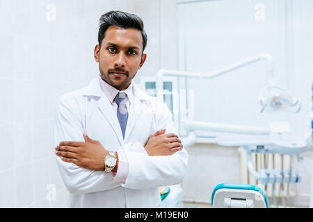 Zahnarzt prüfen Patienten Zähne Porträt einer jungen zuversichtlich indischen männlichen Zahnarzt in der Klinik vor der Frau Doktor, Prüfung der Zähne des Patienten. Stockfoto