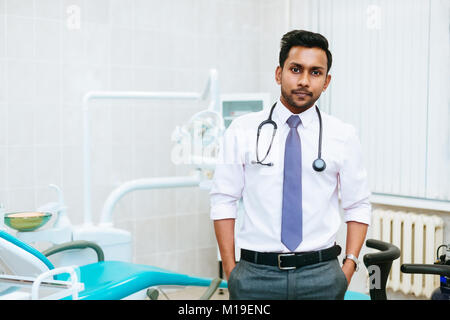 Zahnarzt prüfen Patienten Zähne Porträt einer jungen zuversichtlich indischen männlichen Zahnarzt in der Klinik vor der Frau Doktor, Prüfung der Zähne des Patienten. Stockfoto